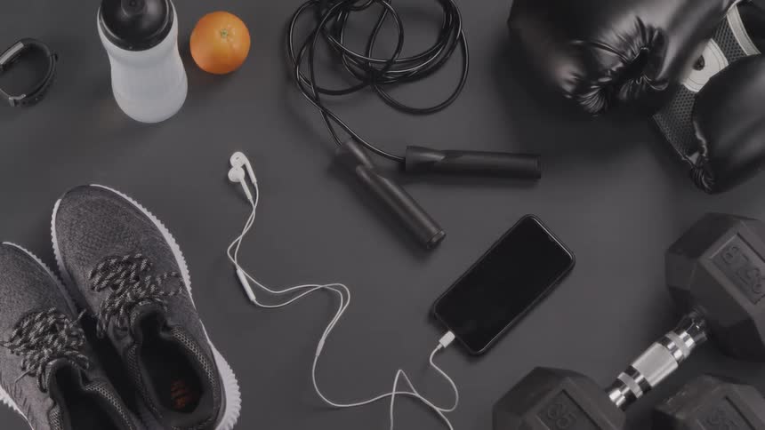 Tennis shoes and athletic equipment sit on a gray surface
