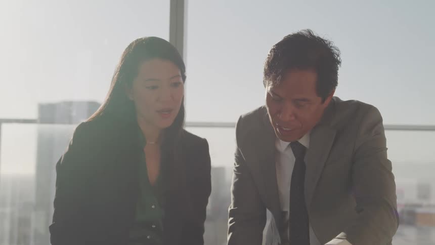 Business people talking over documents in a meeting room at the office