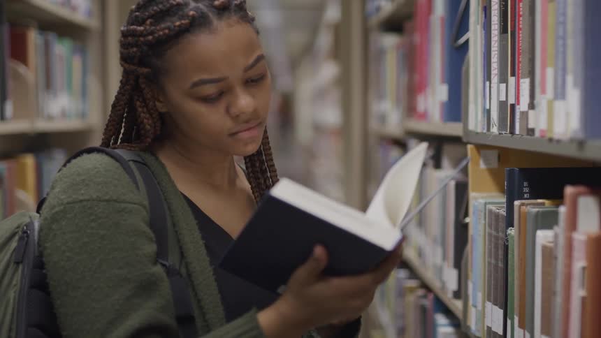 A woman reads a book in the library