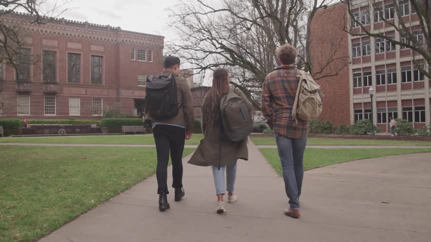 Three students walk on campus together