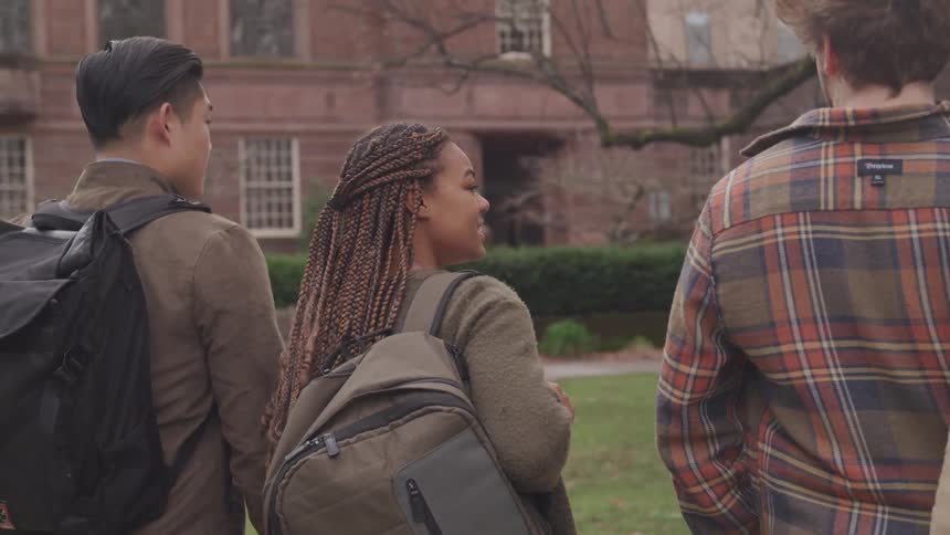 Three people walking towards a school