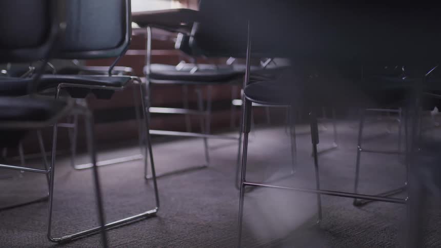 Classroom with desks and black leather chairs in school