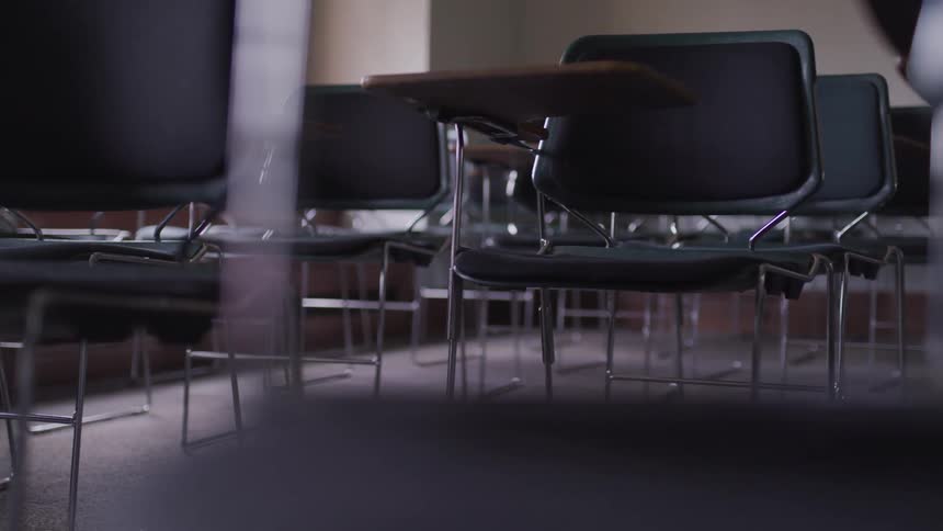 Rows of empty desks in a school classroom