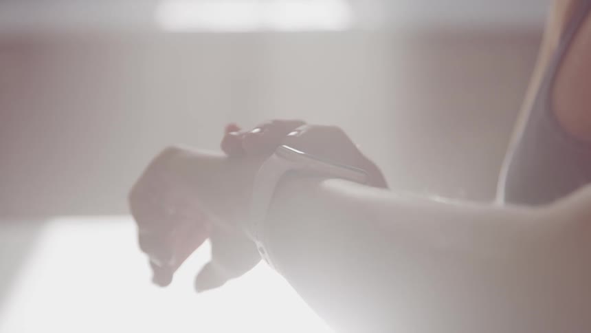 A woman looks at her smart watch