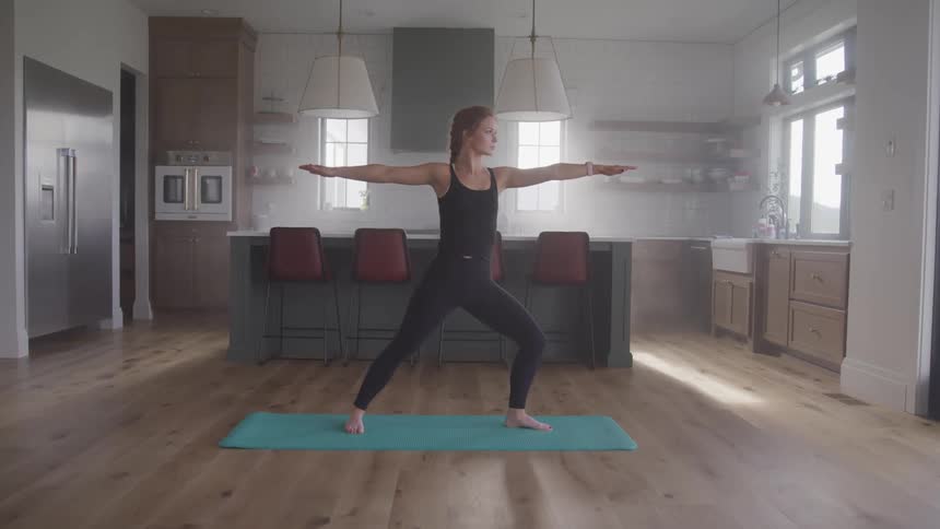 A woman practices yoga in her home