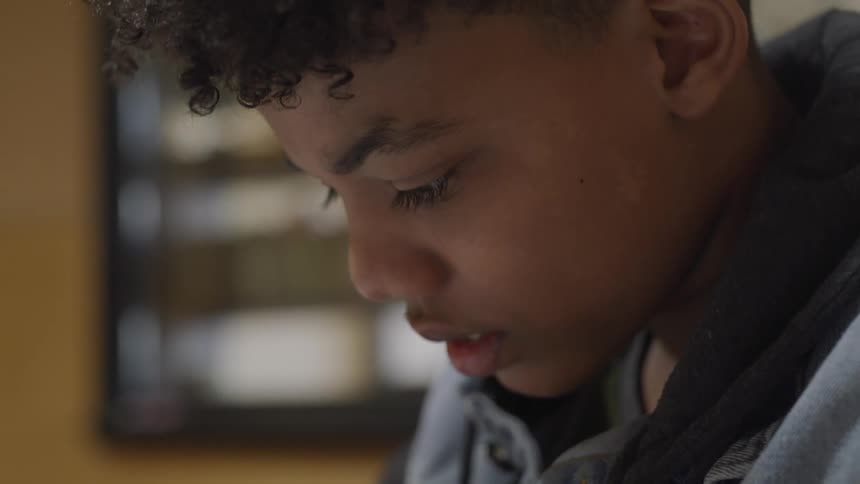 A boy is looking down at something