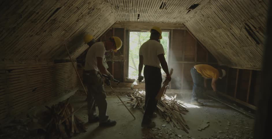 Men work in the attic of a house during the day