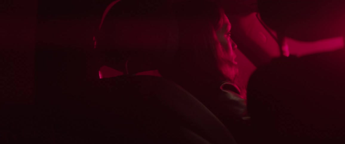 Woman sits in a vehicle with her head against the headrest