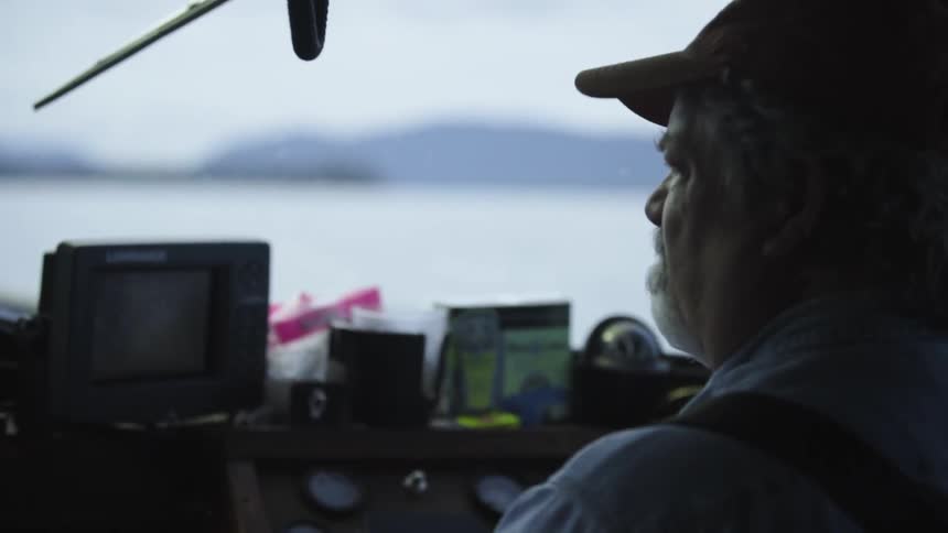 A bearded man drives a boat