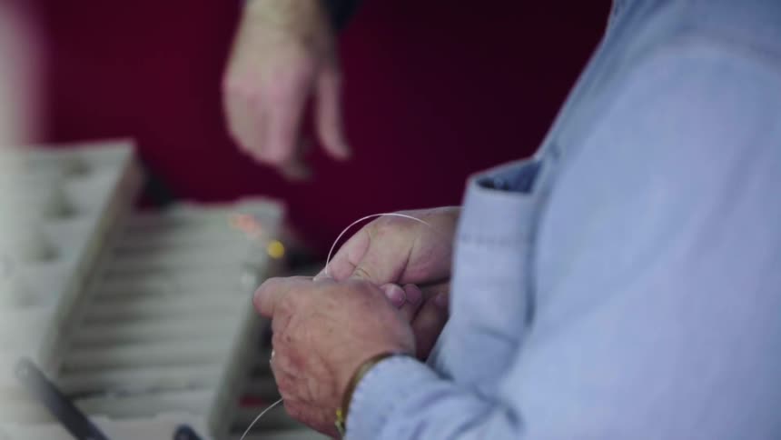 A person is tying some fishing line