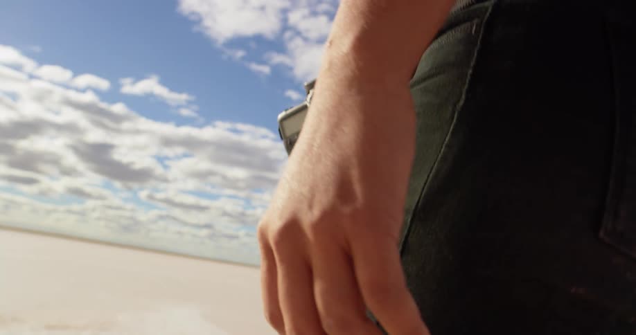 A photographer is walking through the sand