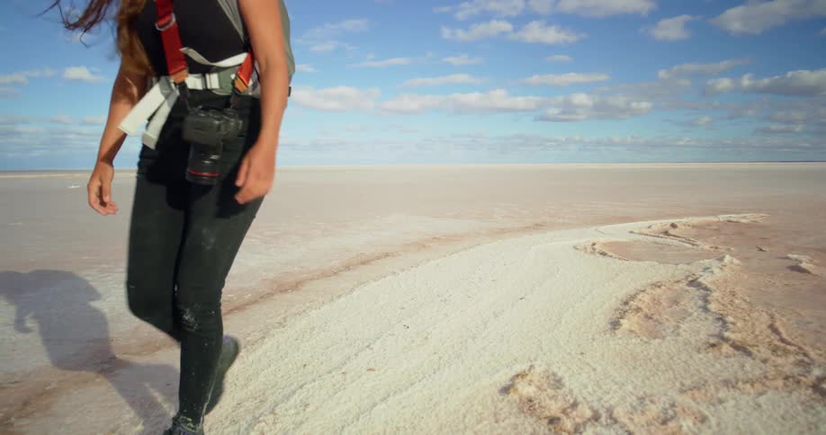 A woman walks through salt flats