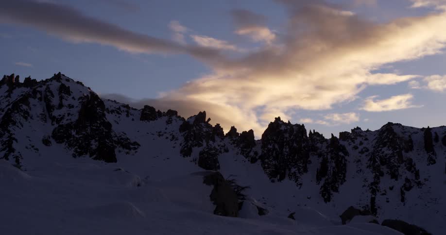 Clouds moving over a snow covered mountain range