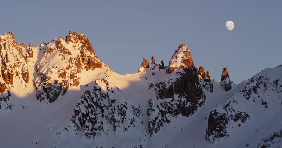 The moon over a snow covered mountain range