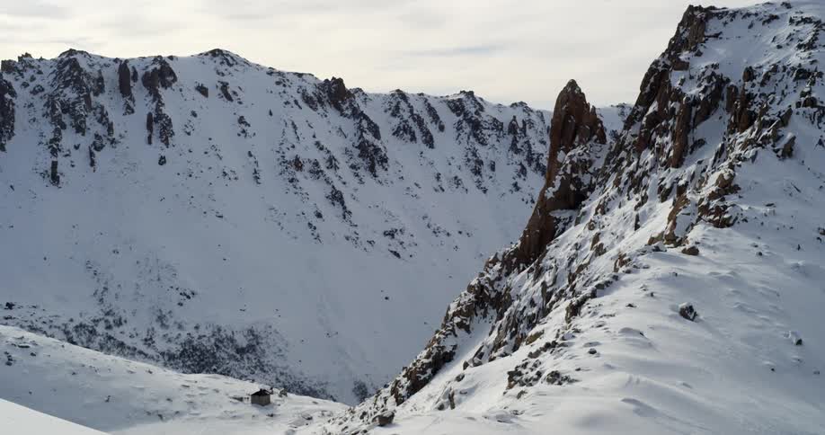 Snow capped mountains beyond a ridge