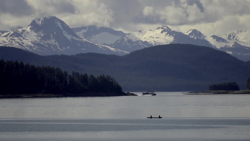 A canoe and boat float on a mountain lake