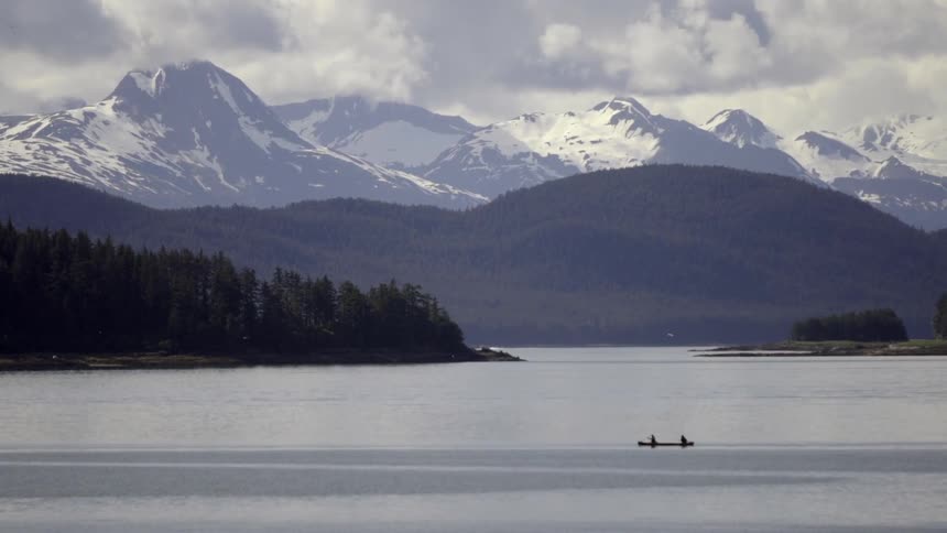 A boat travelling along a mountain lake during winter