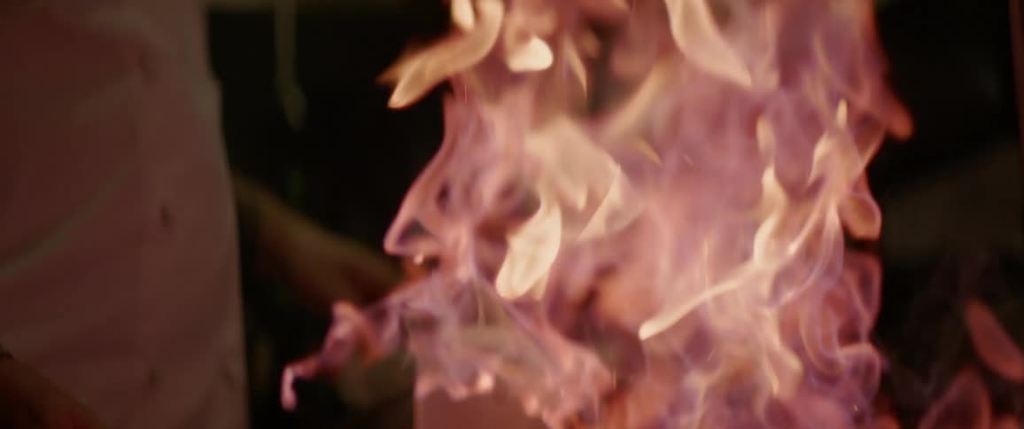 A chef shakes a flaming pan