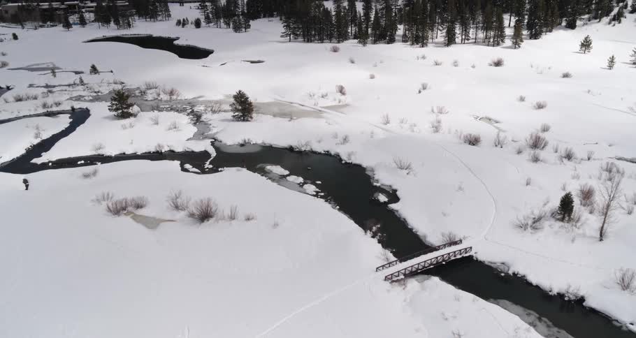 The bridge on the river is covered with snow