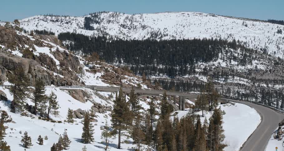 A quiet road in front of a valley and snowy forest