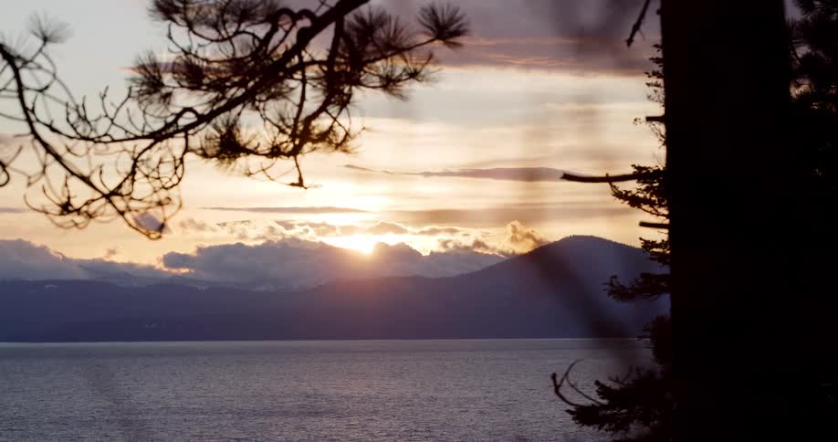 Landscape view of the sun setting over a lake and hills