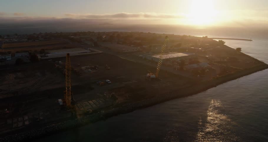 Sun glares from horizon across town waterfront and rippling water