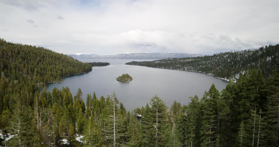 A mountain lake surrounded by pine trees on a winter day