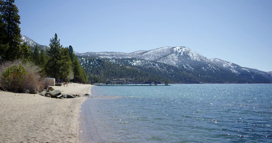 Landscape view of the water and beach with a forest in the back ground