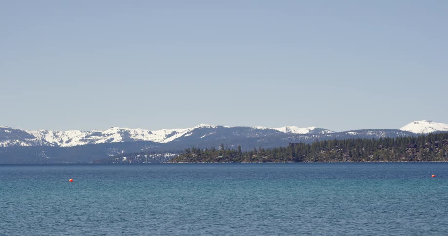 The ocean off the coast of an evergreen forest and mountain range