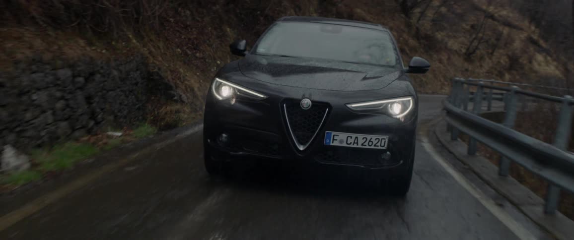 Car drives on a winding country road on a rainy day