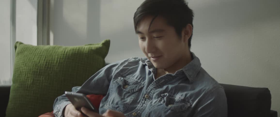 A man reading a book picks up his phone