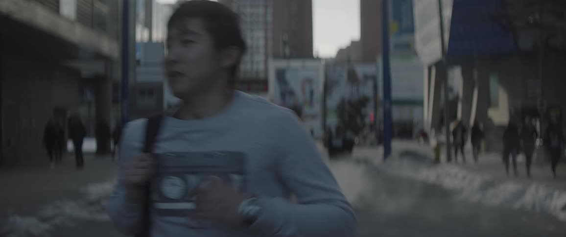 Man runs down a city street looking at his watch