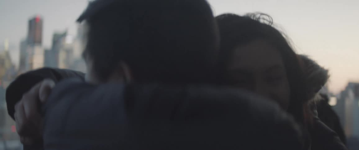 Young man hugging his mother and father outside