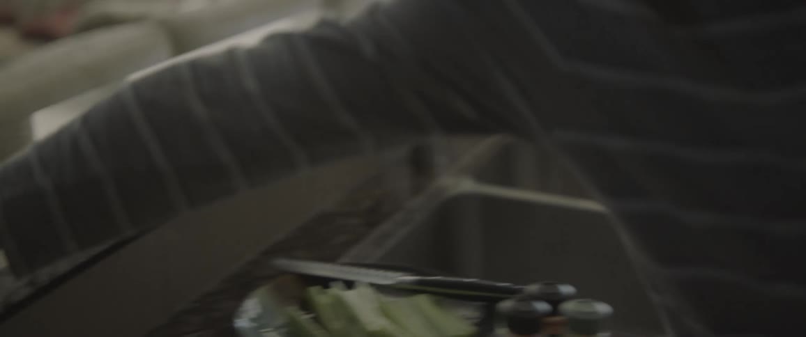 Man is cooking noodles on stovetop then answers cell phone