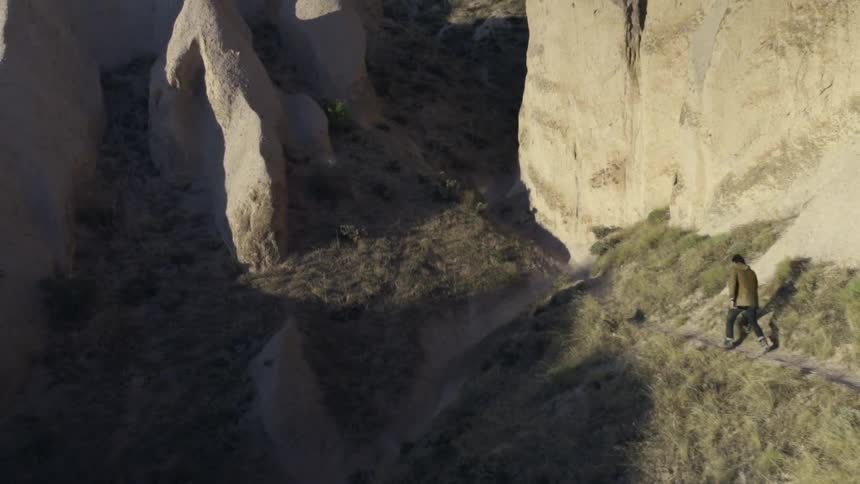 A man walks down a mountain path