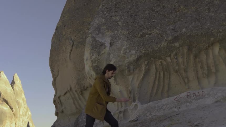 A man carrying a compass navigates a desolate landscape