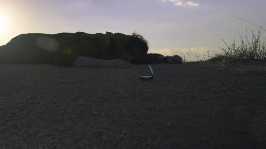 A man laying on the ground at dawn