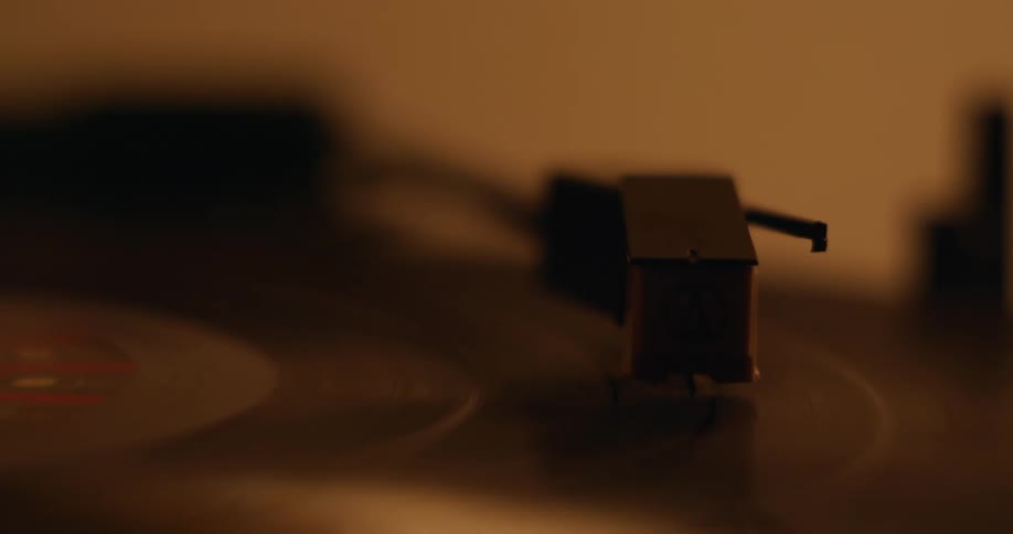 A person plays an album on a record player