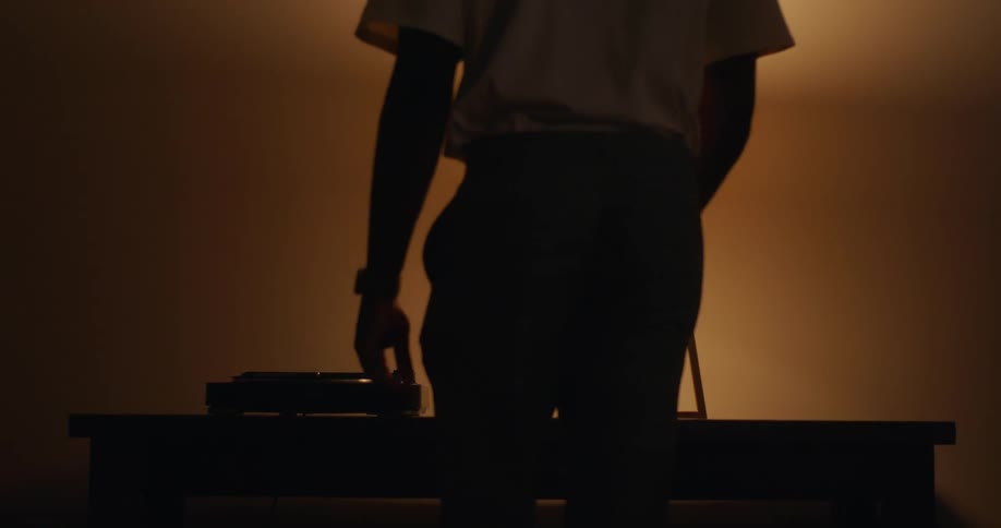 A man at home puts a record player on