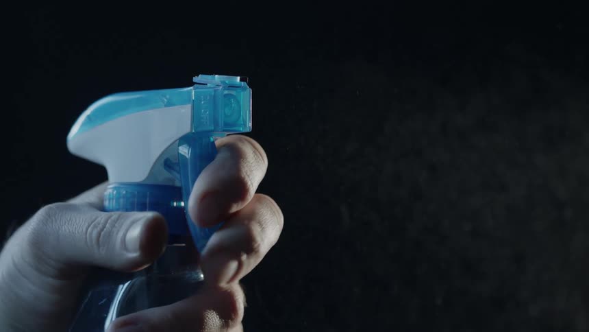 A person sprays a cleaning bottle