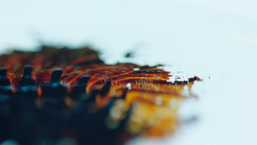 Movement of black and yellow liquid on a white surface