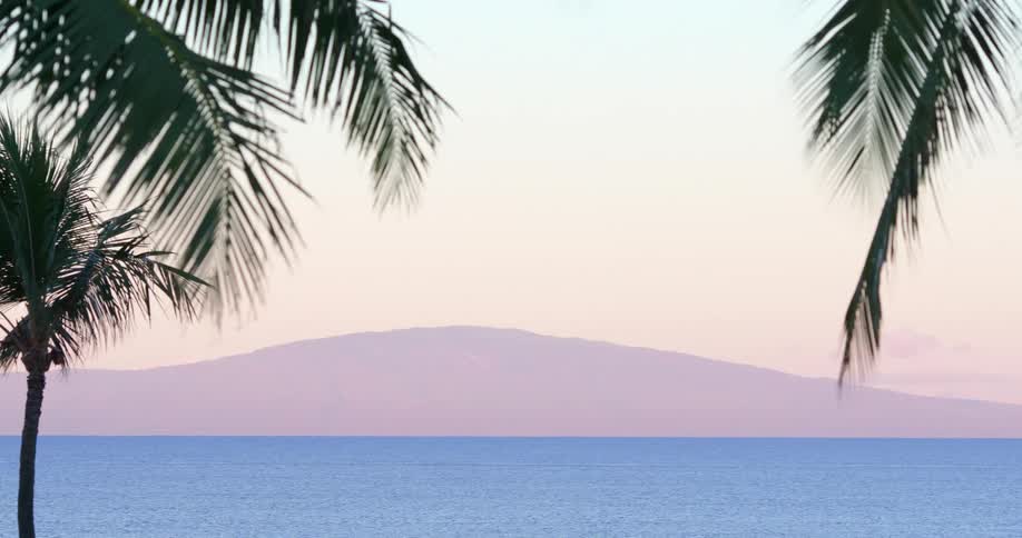 A mountain shrouded in a fog across a gentle bay in the early morning