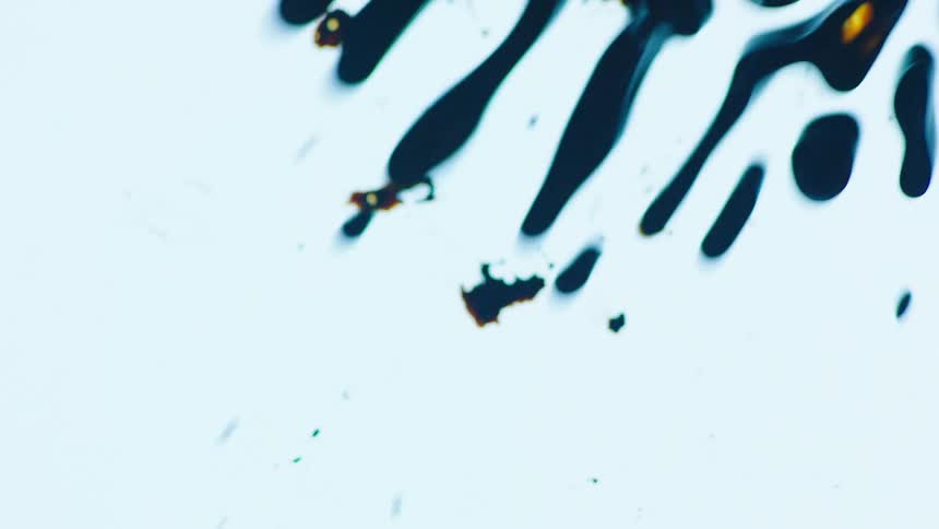 Movement of dark liquid over a white surface