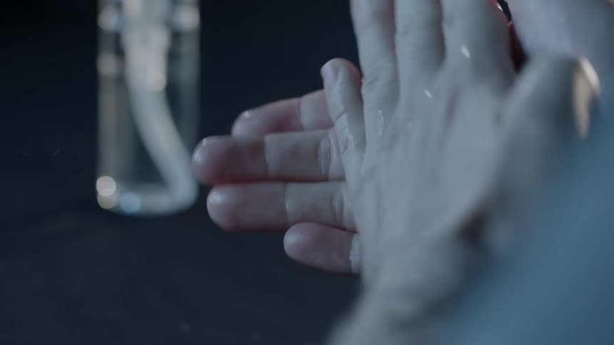 A person cleans their hands with sanitizer