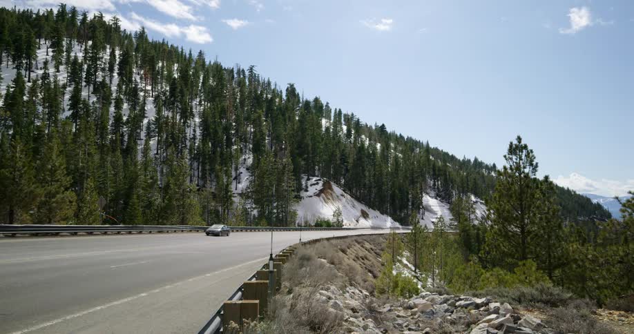 Cars driving on a mountain forest road on a winter day