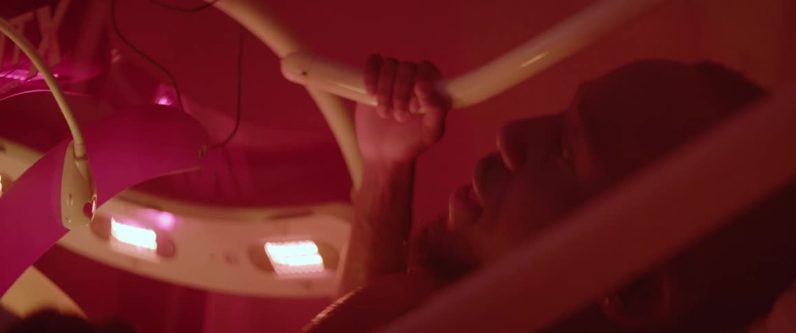 Man pedals in a strange machine with blinking lights