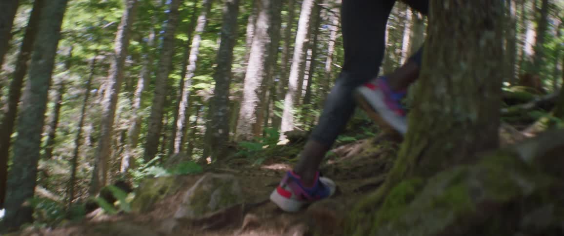 A woman jogs up a path in the forest