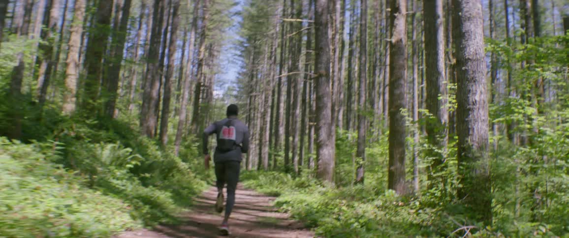 A man jogs in a forest