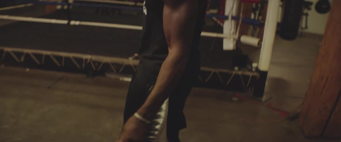 A male athlete is jumping rope in a gym