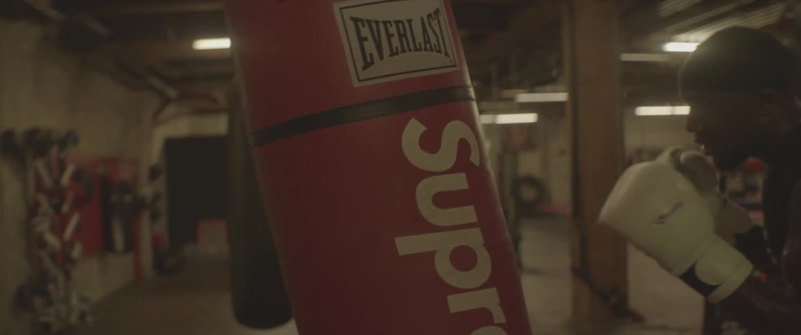 A boxer hits a punching bag while wearing boxing gloves